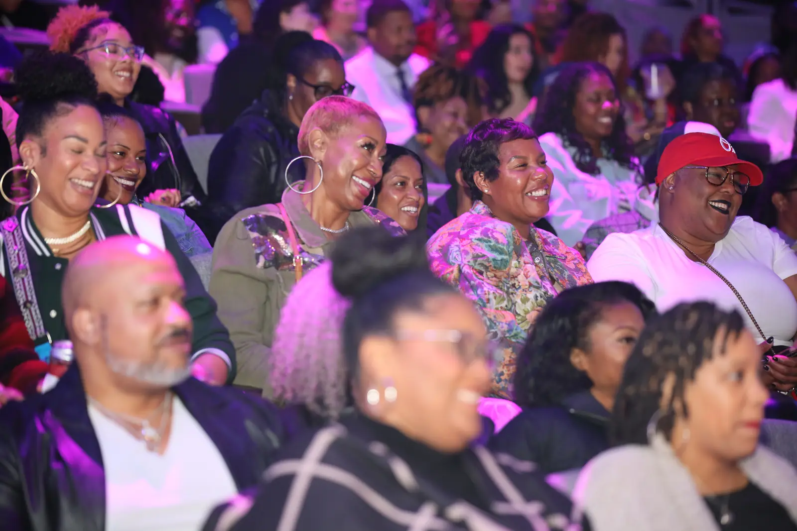Rows of audience members laughing in their seats