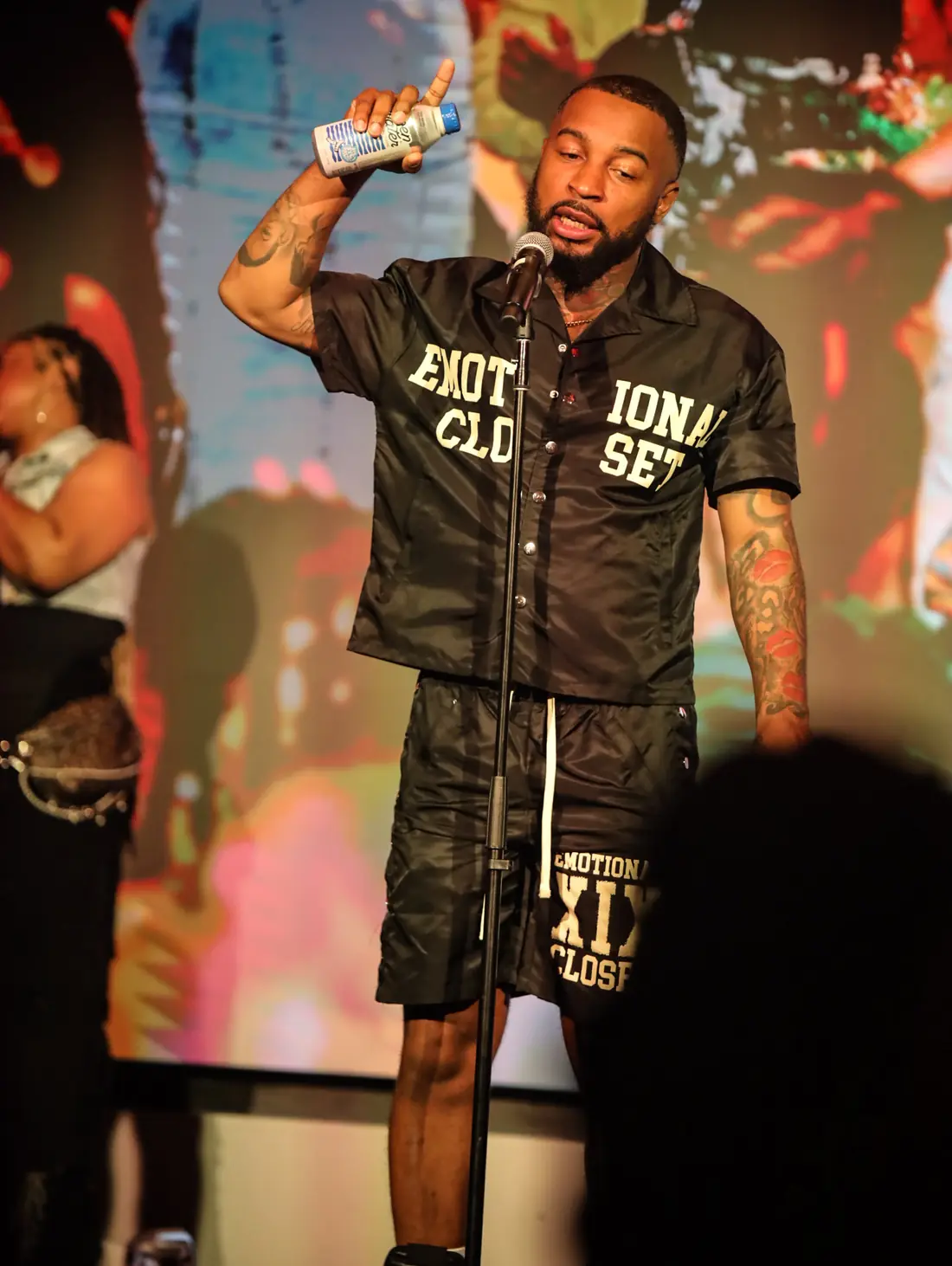 A performer raising a drink on stage